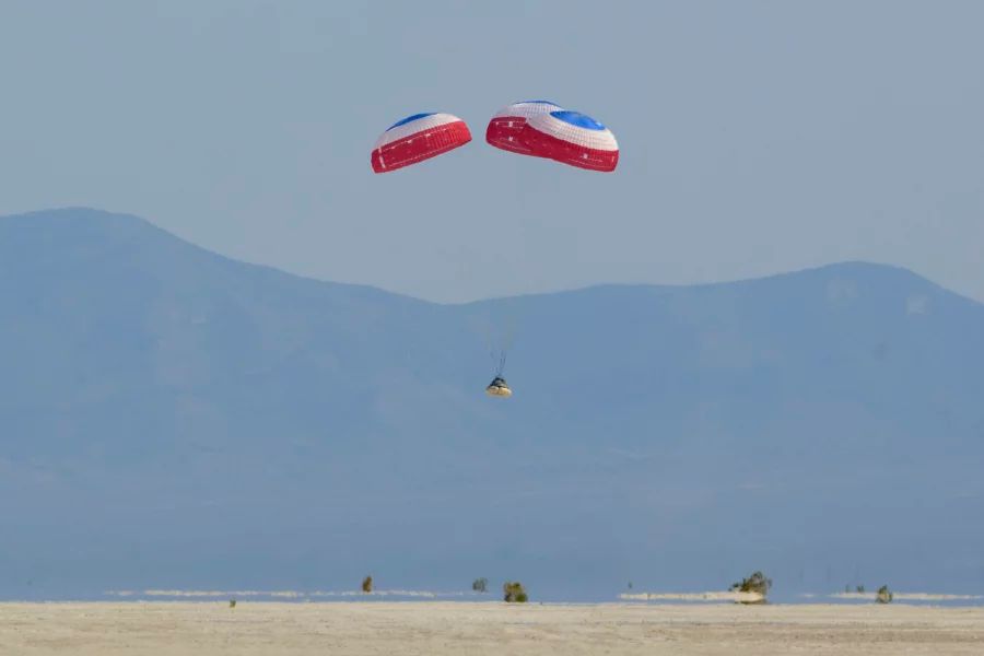 Starliner land met parachutes in open veld in de VS tijdens de onbemande testvlucht in 2022. 