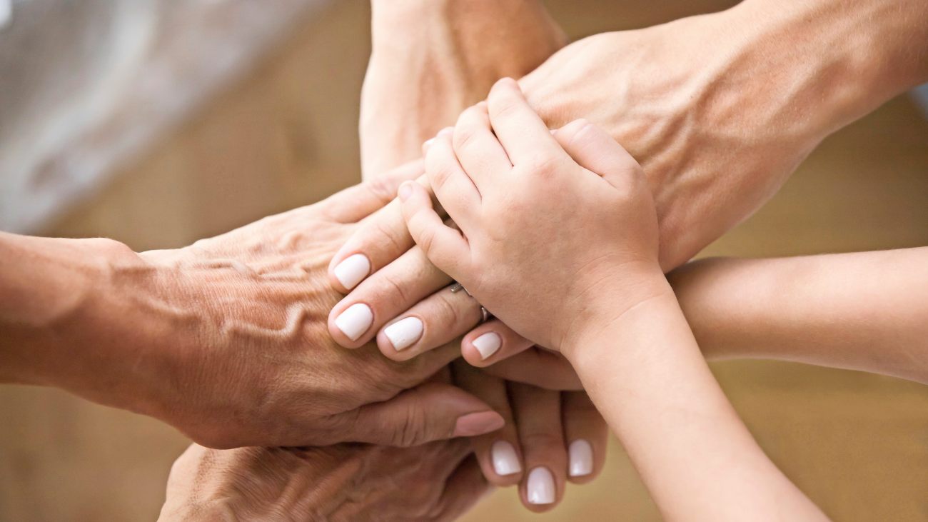 Handen van verschillende generaties op elkaar