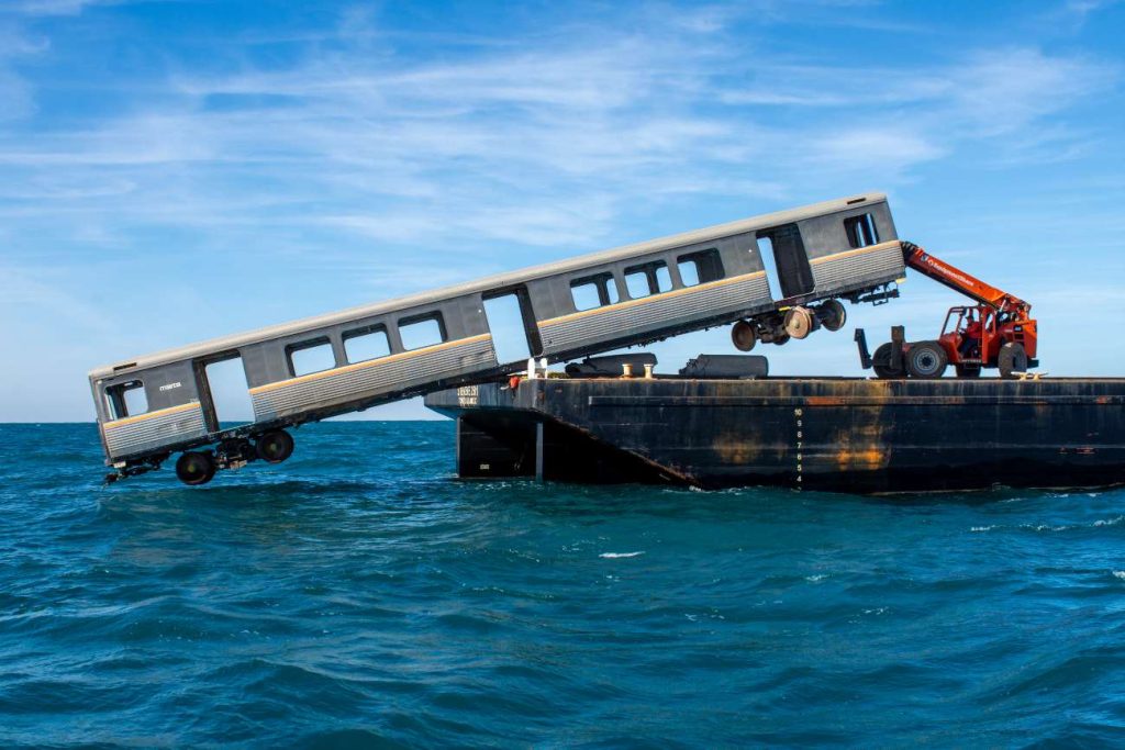 Een treinstel wordt 42 kilometer van de kust de zee in getild.