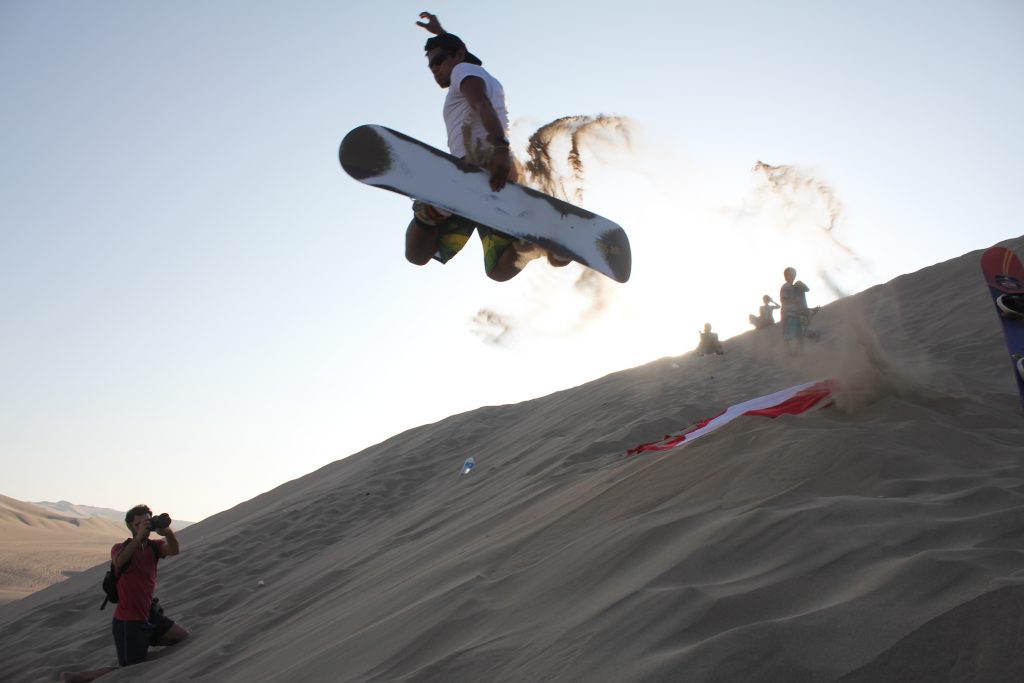 Iemand die 'snowboardt' op zandduinen