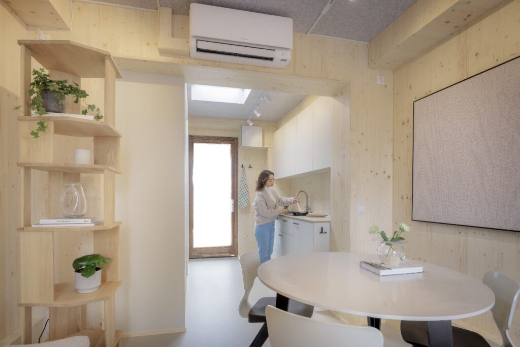 tiny house van windturbine, interieur, vrouw kookt in keuken