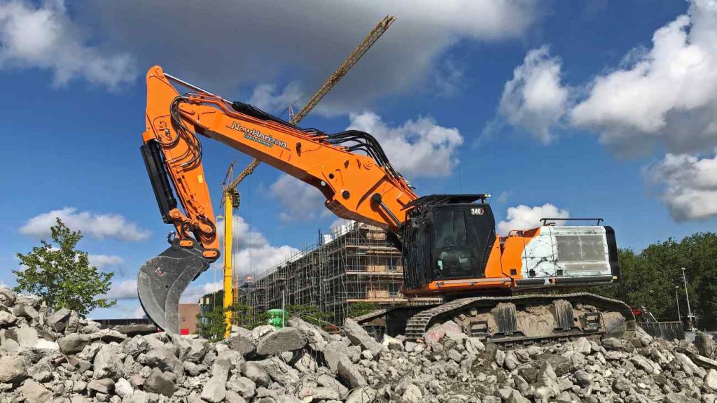 urban mining, graafmachine ontmantelt gebouw